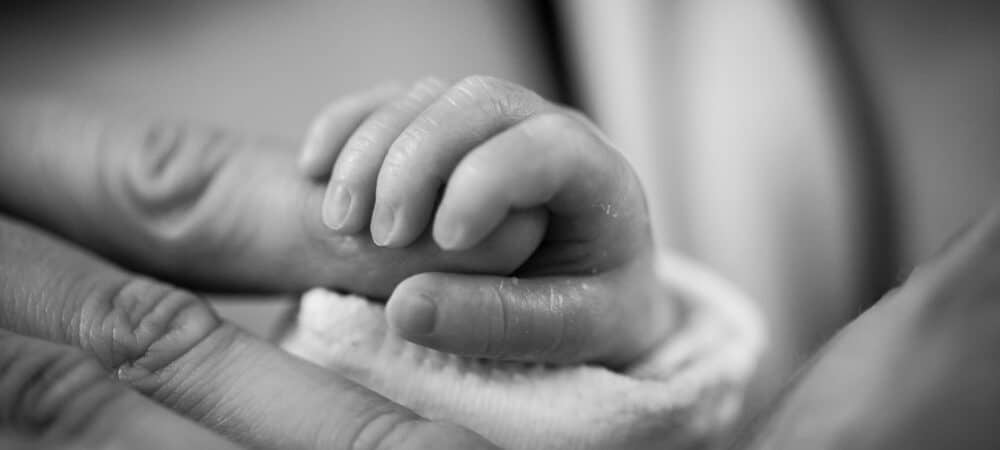 Baby holding moms hand