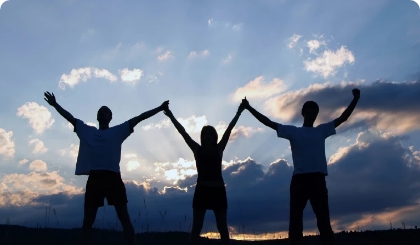 3 people holding hands in the air