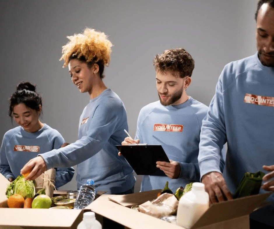 During Recovery Month, a group of four dedicated volunteers package food for a drive, exemplifying the community spirit and shared purpose of giving back and supporting those on their recovery journey.