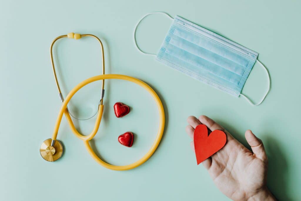 A picture about heart health for the blog "How do opioids affect the heart". In the photo there is a heart cut out with a mask and a stethoscope. 