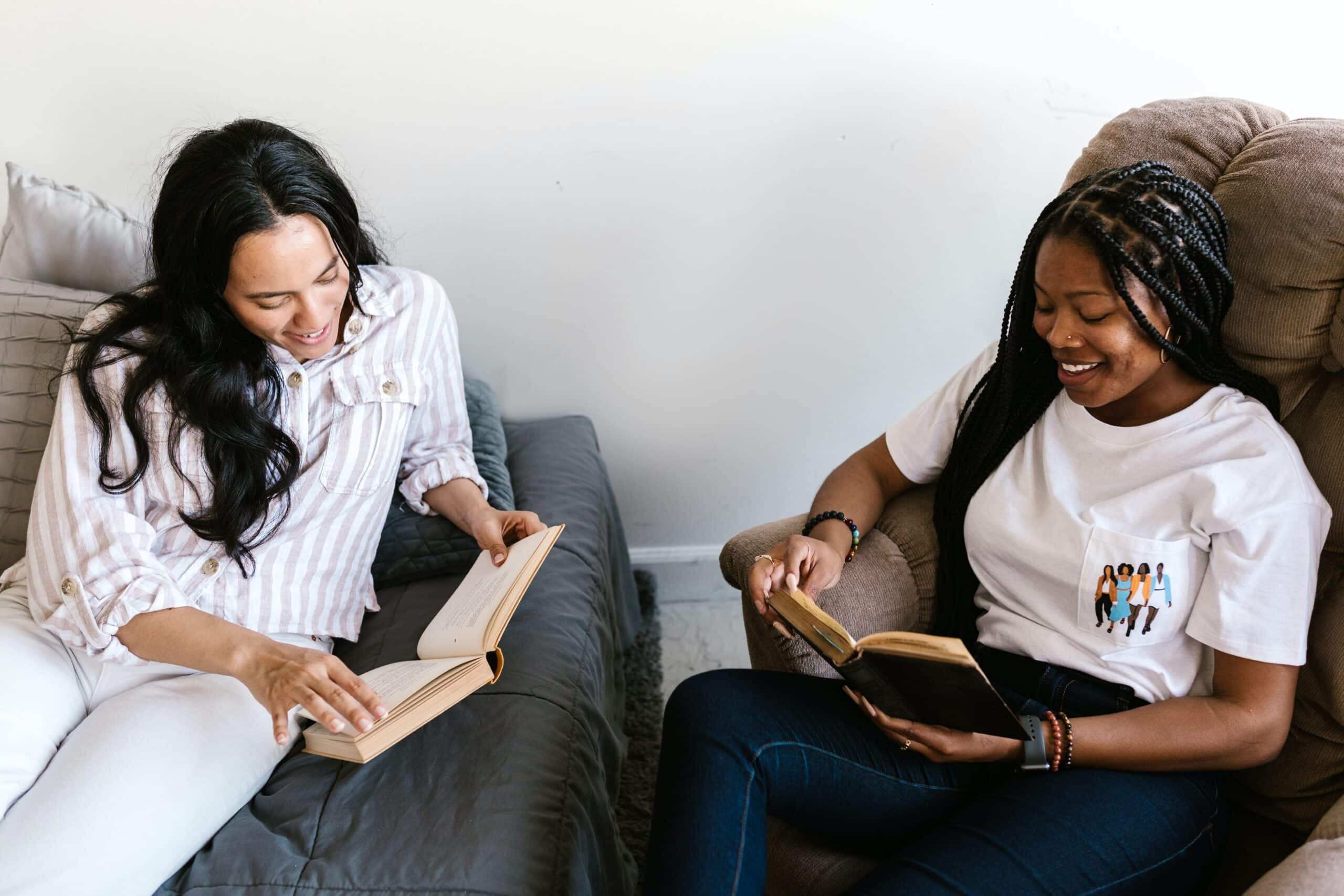 Two roommates in recovery sit in chairs reading together, enjoying each other's company.