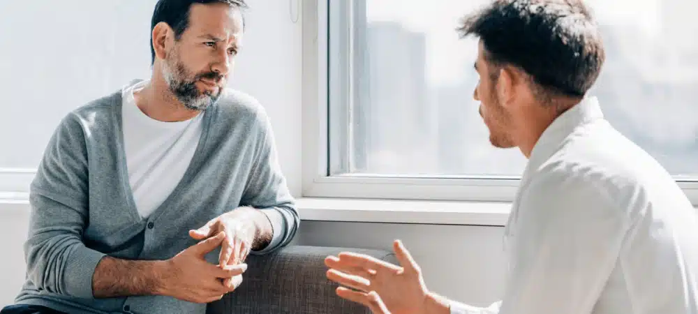 Two men talking on couch
