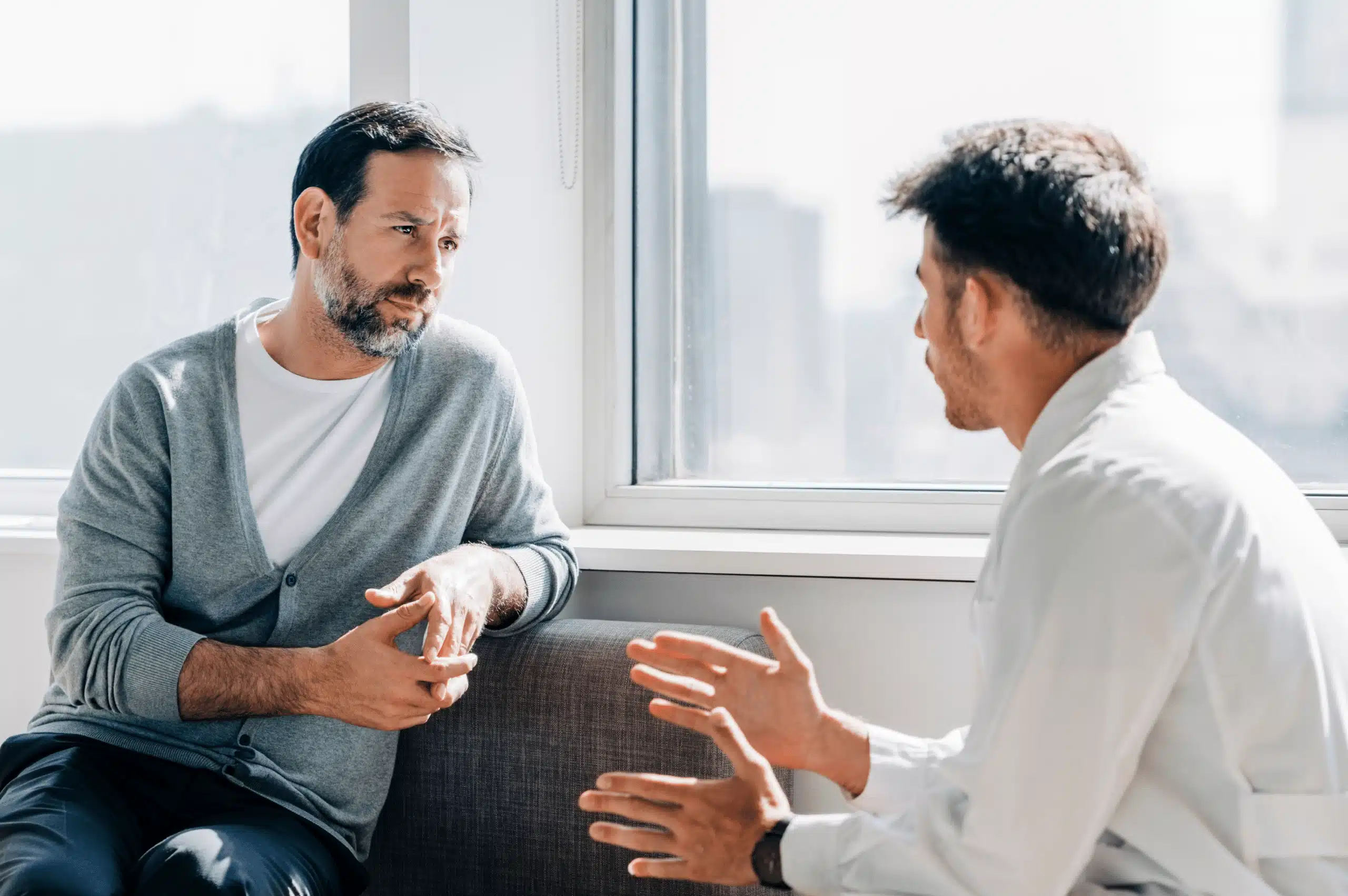 Two men talking on couch